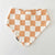 Bohemian Babies made in the USA organic cotton bandana bib. Snap closure. Rose Pinkcheckered print. dusty rose checkers on an off-white background. Front view.